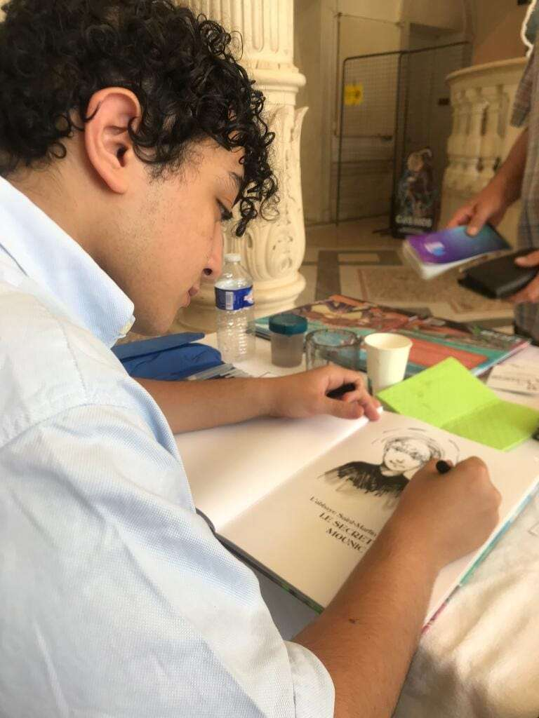 Belkaseum en train de dessiner dans un carnet